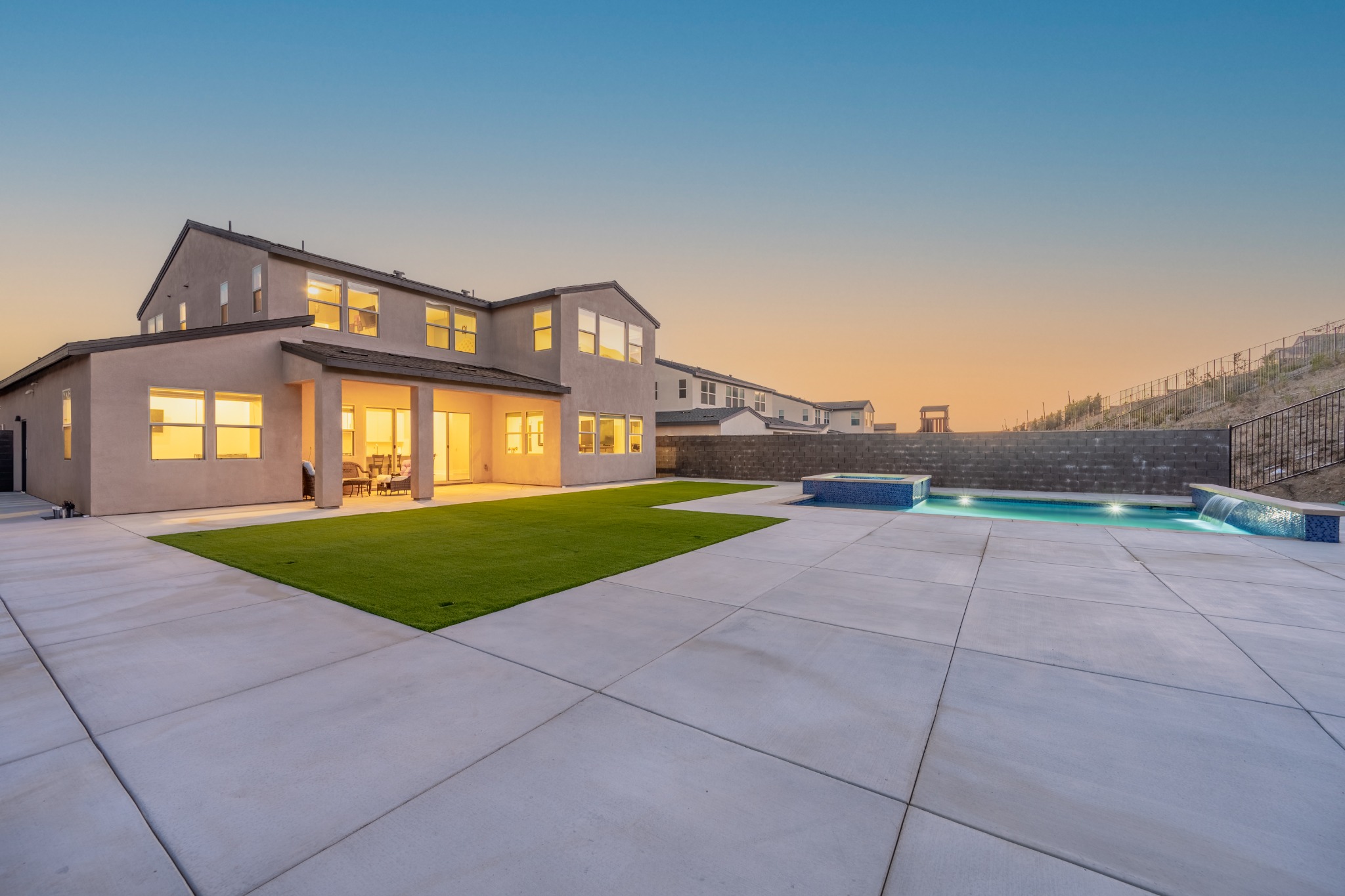 Butterfly backyard, pool and illuminated exterior at twilight